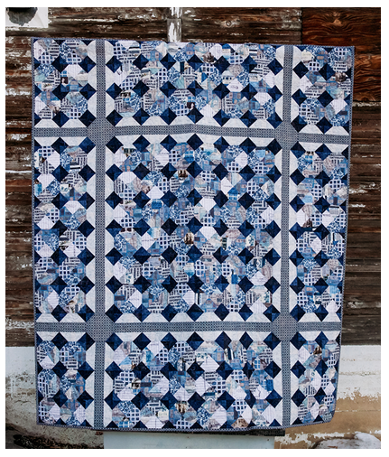 Image of a blue and white quilt which looks like a tiled floor
